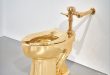 Il water d’oro da 10 milioni di dollari di Maurizio Cattelan esposto in mostra prima dell’asta di Sotheby’s a New York.